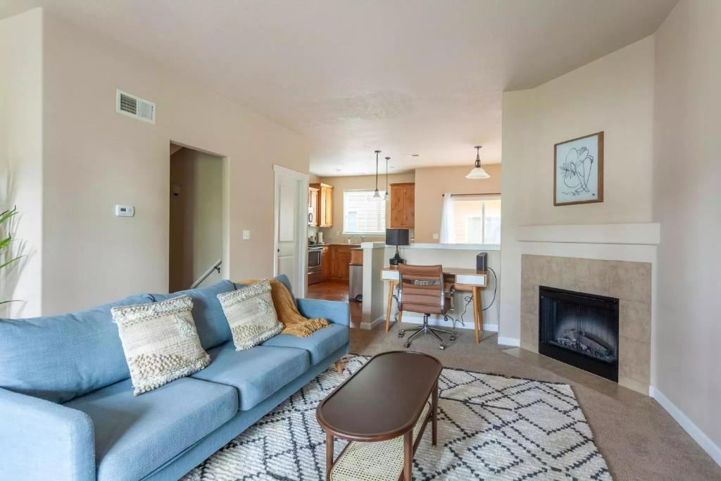 Una sala de estar con un sofá azul y una chimenea. en Family friendly 3 story townhouse with workspace, en Beaverton