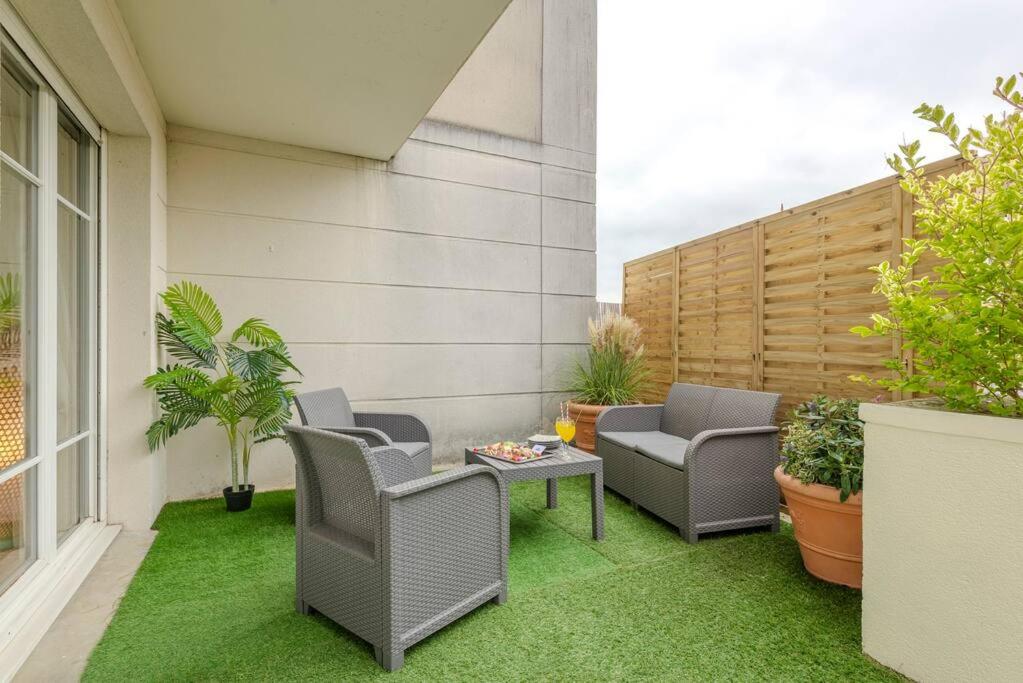 d'une terrasse avec des chaises et une table sur gazon. dans l'établissement Agapé by Kleidos -Disney à 10min, T2 , 4P, Parking gratuit et terrasse, à Magny-le-Hongre