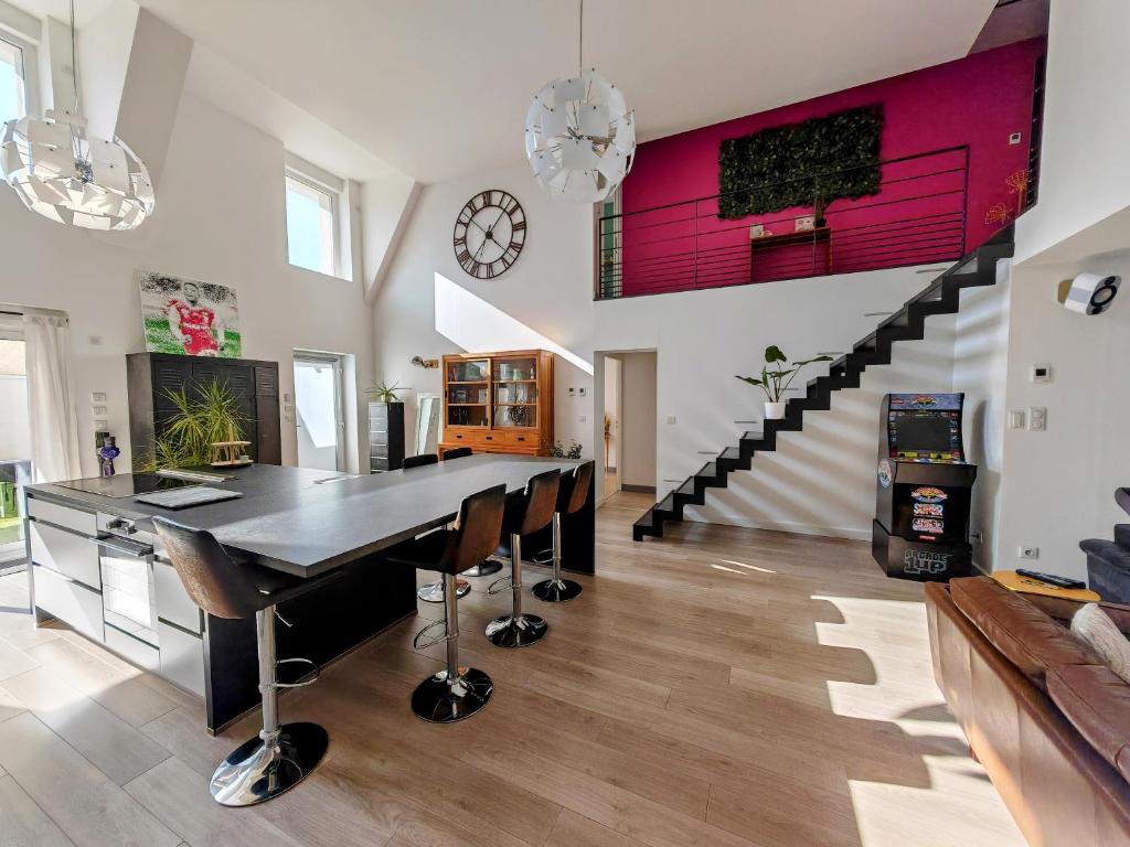 une cuisine avec une table à manger et un escalier dans l'établissement Loft en Champagne proche Reims, à Courcy