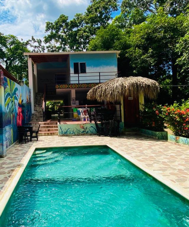 a swimming pool in front of a house at hostal los cascabeles de la sierra in Santa Marta