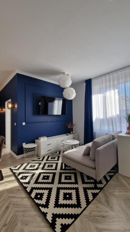 a living room with a couch and a blue wall at Blue Dream Apartment-City Center in Satu Mare