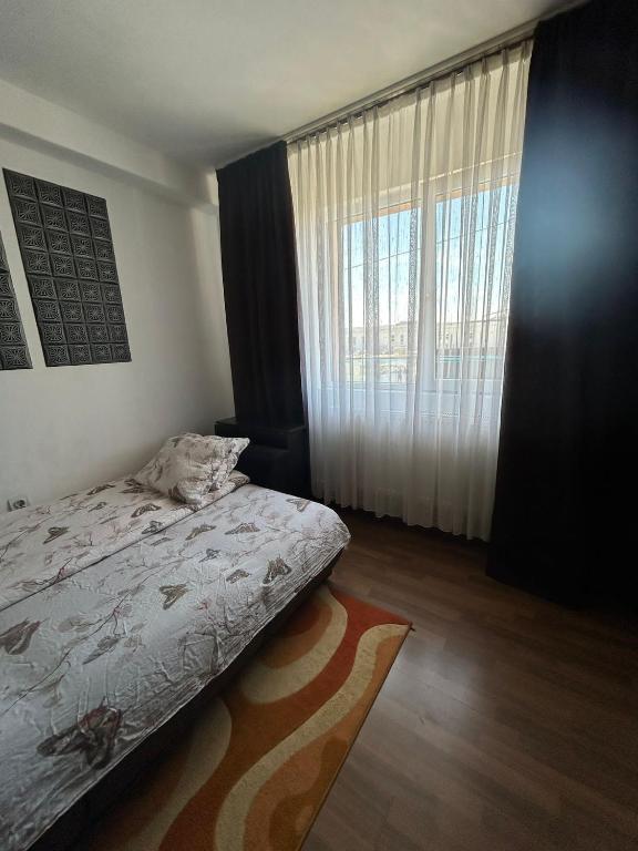 a bedroom with a bed and a large window at Garso Fabricii in Someşeni