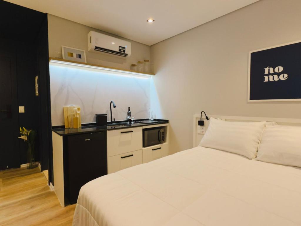 a bedroom with a white bed and a sink at Apê Brás - Shopping Plaza Polo in Sao Paulo