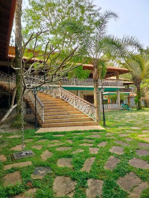 a staircase leading to a house with palm trees at Mansão Sunset Beach House in São Sebastião