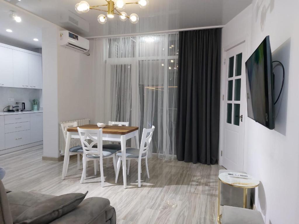 une cuisine et une salle à manger avec une table et des chaises dans l'établissement აპარტამენტი თეა ზღვიდან 50 მეტრში, à Batoumi