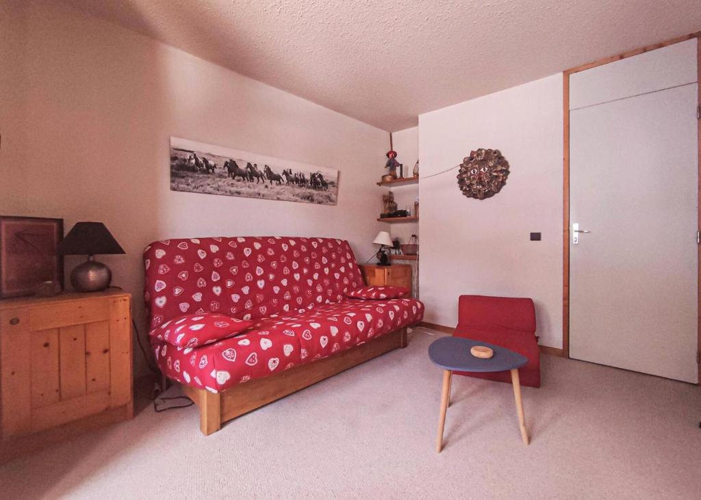 un salon avec un canapé rouge et une table dans l'établissement Résidence Roches Blanches G - ROCHES BLANCHES 35 MAE-6571, à Valmorel
