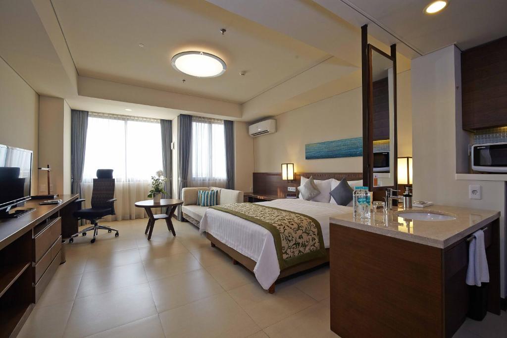 Postel nebo postele na pokoji v ubytování Axia South Cikarang Service Apartment