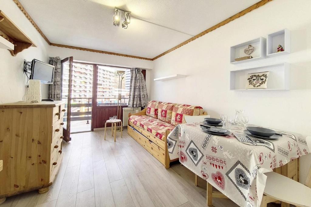 un salon avec une table et un canapé dans l'établissement Résidence Oisans - Studio agréable · Skis aux pieds · Balcon MAE-3394, aux Menuires