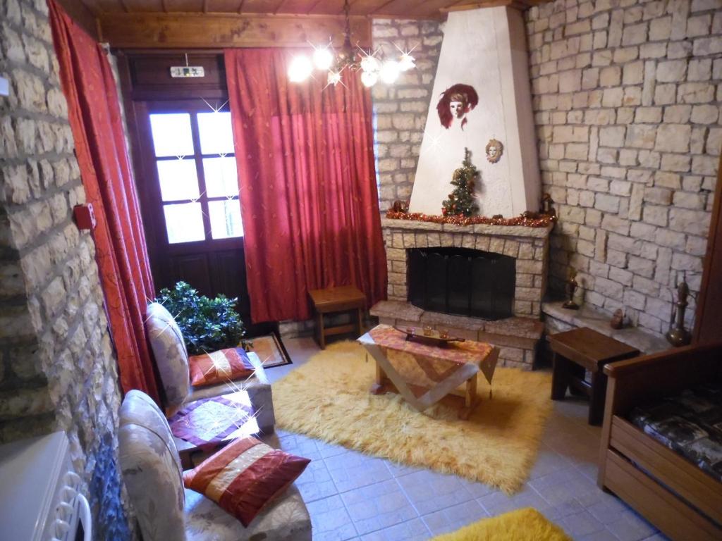 a living room with a fireplace and red curtains at Elatos Rooms in Mikro Chorio