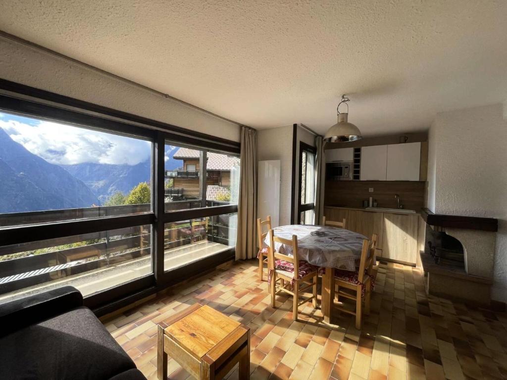 a kitchen and dining room with a table and a large window at Résidence Sequoias - Charmant appartement avec vue époustouflante MAE-5351 in Les Deux Alpes