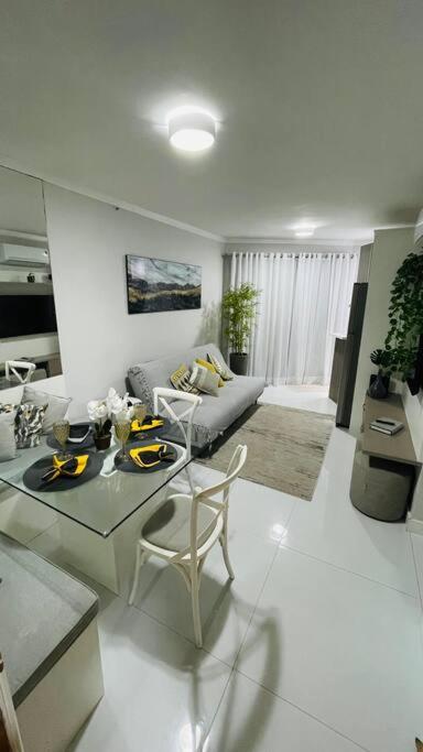 a living room with a table and a couch at Flat pé na areia no Recreio in Rio de Janeiro