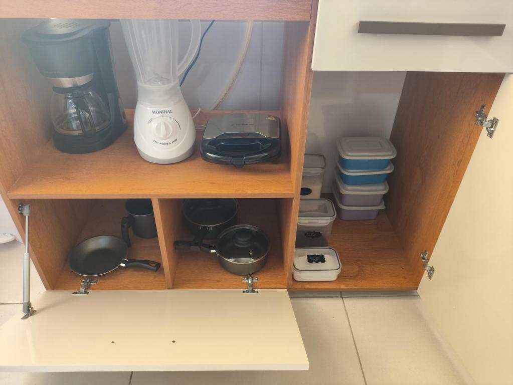 a cupboard with a blender and other kitchen items at Studio Friends - Centro BH - Ótima localização in Belo Horizonte