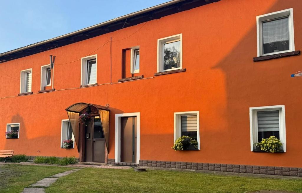 an orange building with a door and windows at Apartament nad Włodzicą in Nowa Ruda