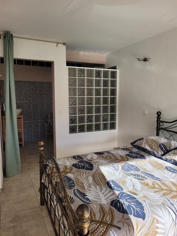 a bedroom with a bed and a window at Le Triton in Deshaies