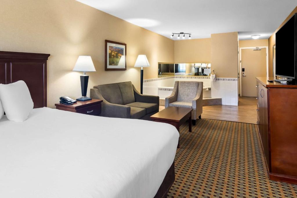 a hotel room with a bed and a living room at Best Western Plus Osoyoos Hotel & Suites in Osoyoos