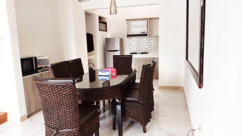 a dining room with a table and chairs at Vila Keluarga Syariah Mawar#9, Dago Resort, 3BR dengan View Pegunungan dan Fasilitas Premium in Bandung