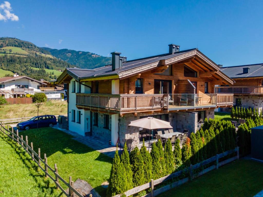a large wooden house with a deck and a yard at Chalet Lengberg B1 in Niedernsill