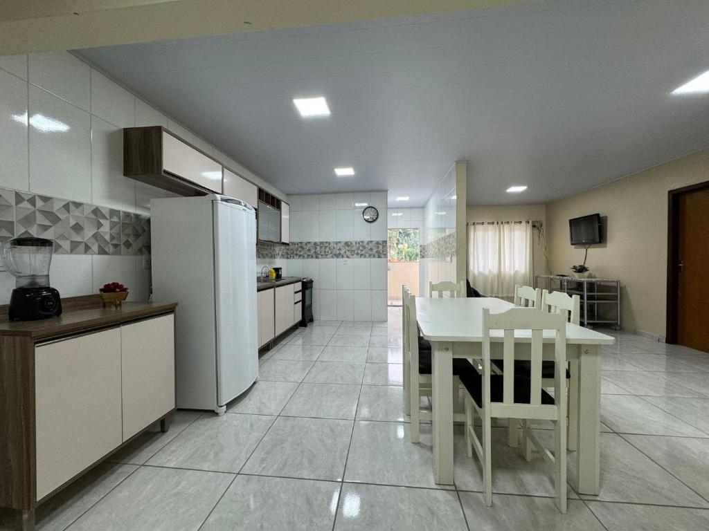 Conforto para 5 hóspedes em Blumenau DP9335 في بلوميناو: مطبخ مع طاولة بيضاء وثلاجة