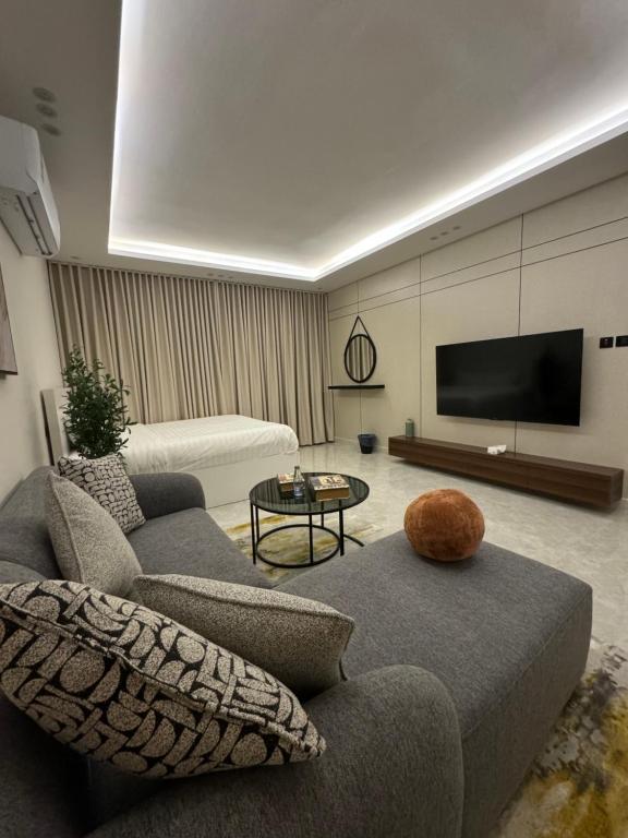 Una sala de estar con un sofá y un televisor de pantalla plana. en استديو فندقي - مودرن فاخر كبير جدا, en Riad