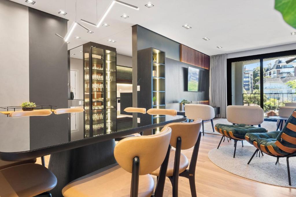 a dining room with chairs and tables and a bar at Requinte a passos da Rua Torta by Achei Gramado in Gramado