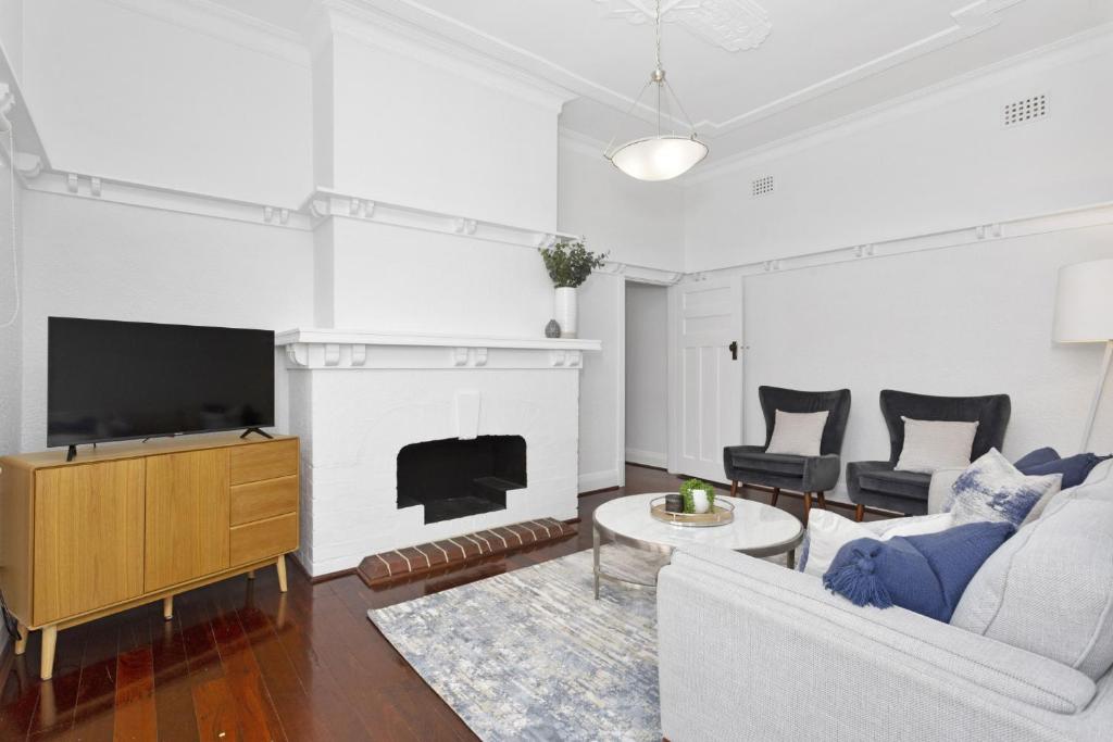 a living room with a couch and a fireplace at Elegant Art Deco Semi Detached 2-Bed Home by Parks in Perth