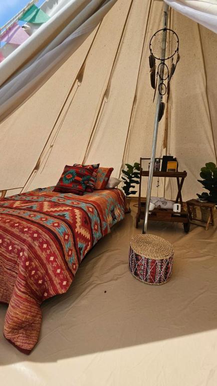 a bedroom with a bed in a tent at El Mirador Family Glamping INDIA AMERICANA in Estancia de Itargua
