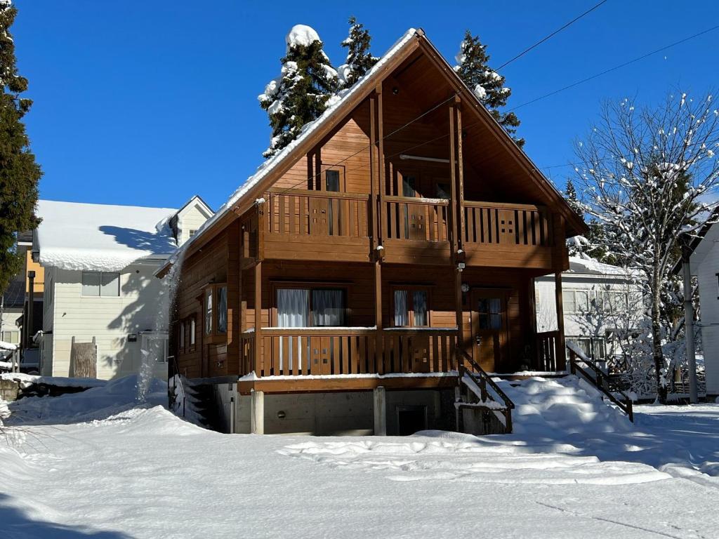 a log home in the snow with snow covered yard at Swiss Chalet - Vacation STAY 11450v in Iida