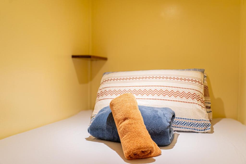 a stuffed animal sitting on a bed next to a pillow at CocoRico Hostel in San Vicente