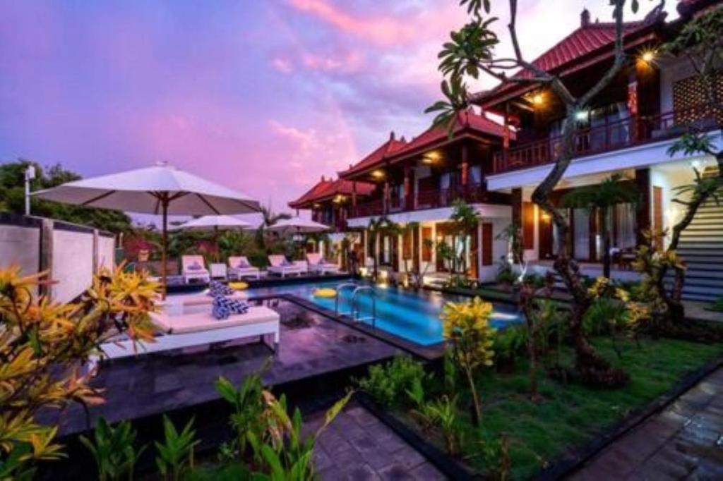 a villa with a swimming pool in front of a house at Lembongan Cempaka Villa & Restaurant in Nusa Lembongan