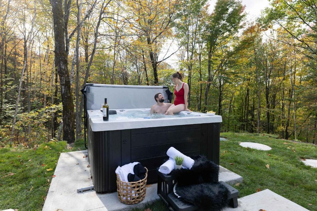 a man and a woman in a bath tub at Mini chalet Ecohaven - SPA in Brownsburg