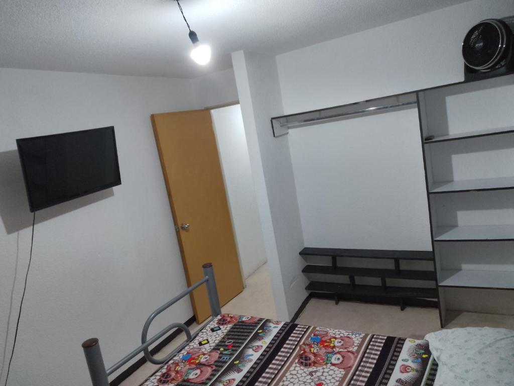 a small room with a bed and a television at Renta de Habitaciones en muy buena ubicación in San Juan Xilotzingo