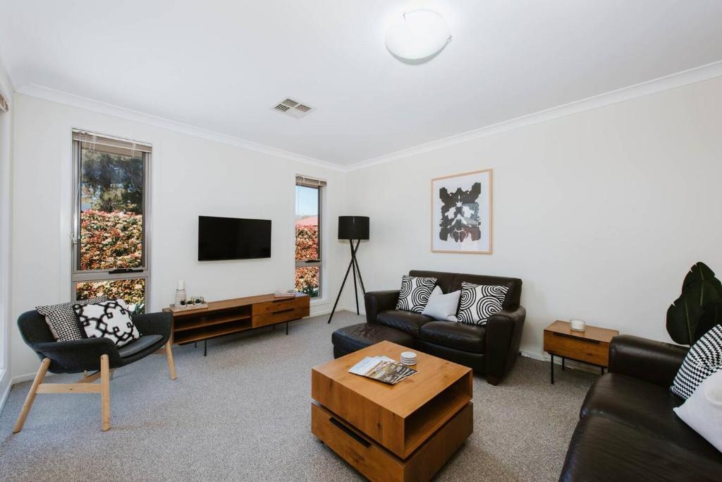 un soggiorno con un divano e una TV di Denison at The Willows - Tranquil Country Retreat a Mudgee