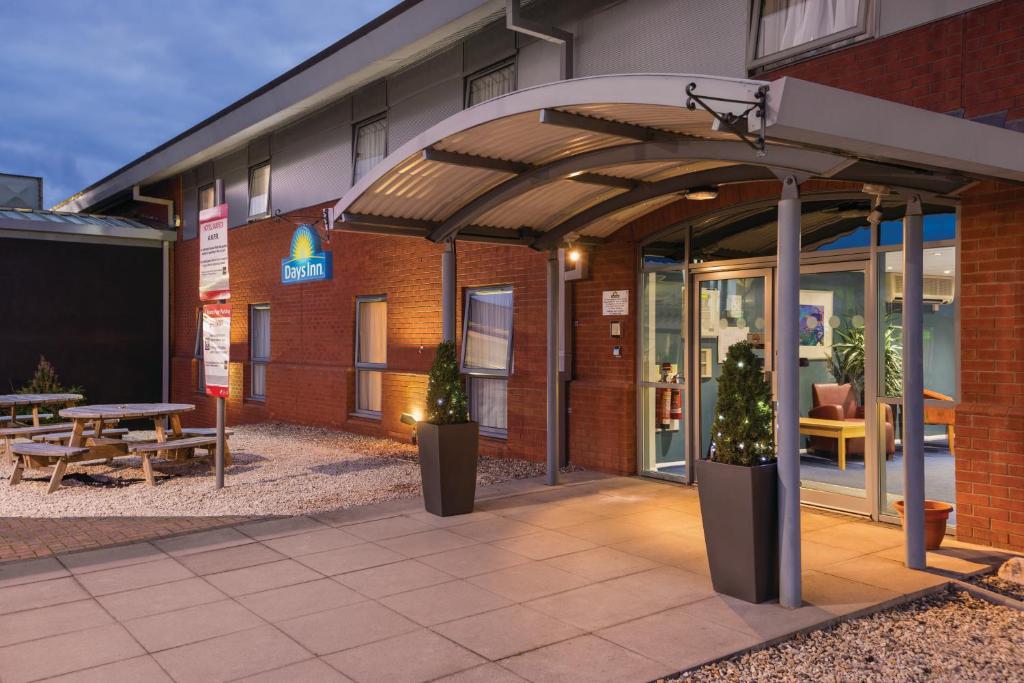 an entrance to a building with a patio and a table at Days Inn by Wyndham Telford Ironbridge in Telford