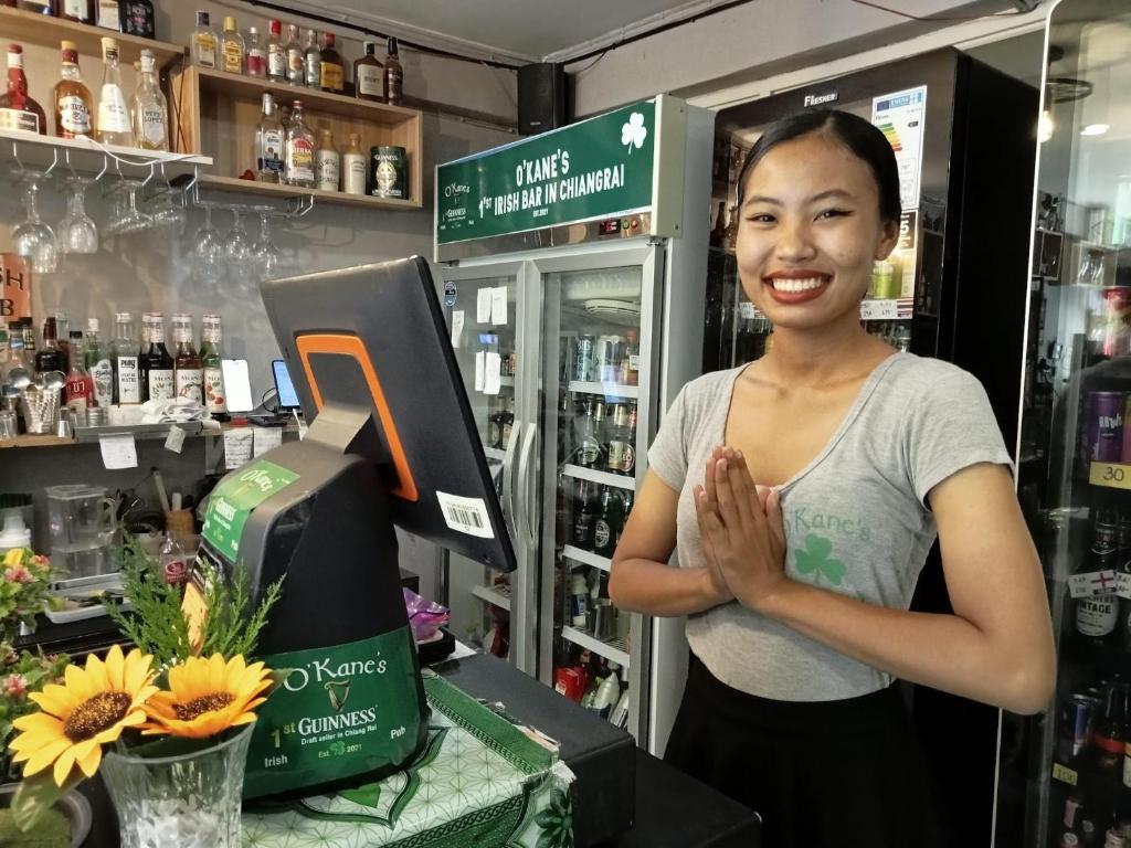 a woman standing in a store with her hands at O'Kane's Pub and Hostel in Chiang Rai