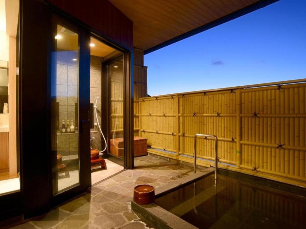 a bathroom with a tub and a shower in it at Manten no Yado in Gujo