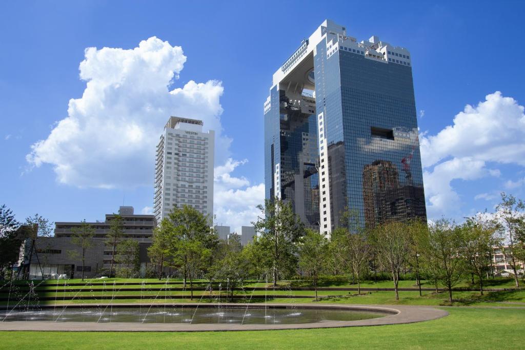 two tall buildings in a park with a fountain at The Westin Osaka in Osaka