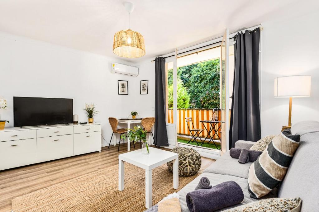 un salon avec un canapé et une télévision dans l'établissement Le landella, à Menton