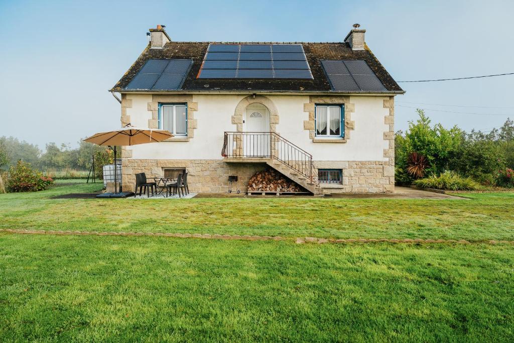 a house with solar panels on the roof at Charmante maison néo-bretonne in Plumaudan