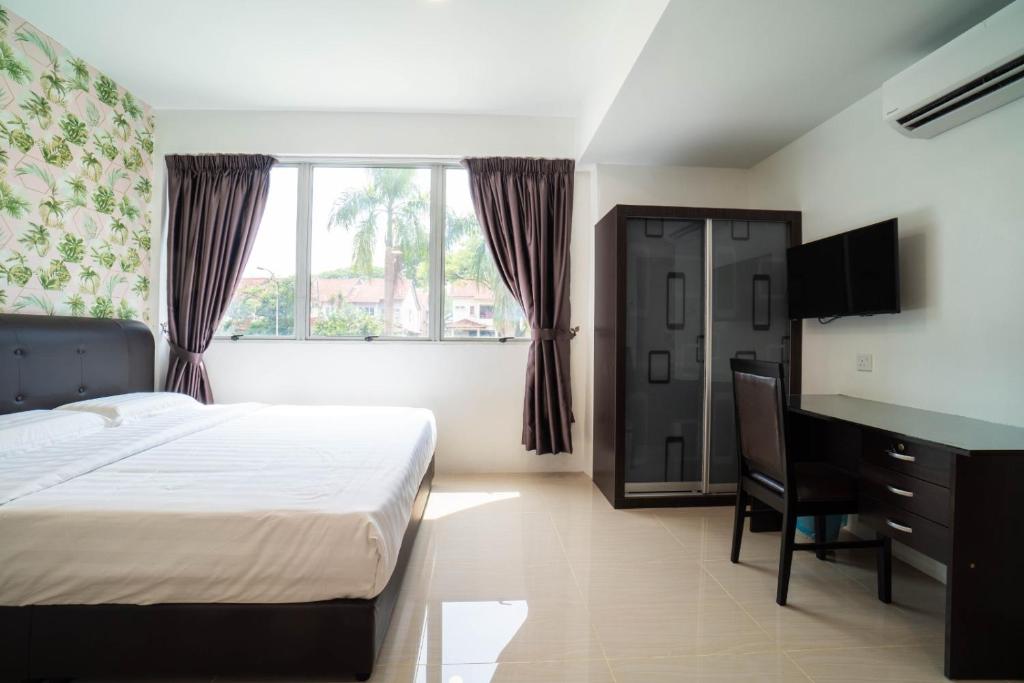 a bedroom with a bed and a desk and window at Crystal Garden Hotel (Tasik Selatan) in Kuala Lumpur
