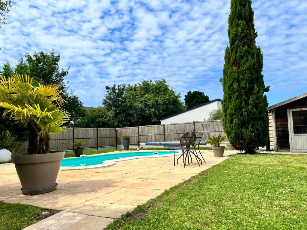 a backyard with a swimming pool and a fence at Le Logis de La Baule - Maison climatisée piscine in La Baule