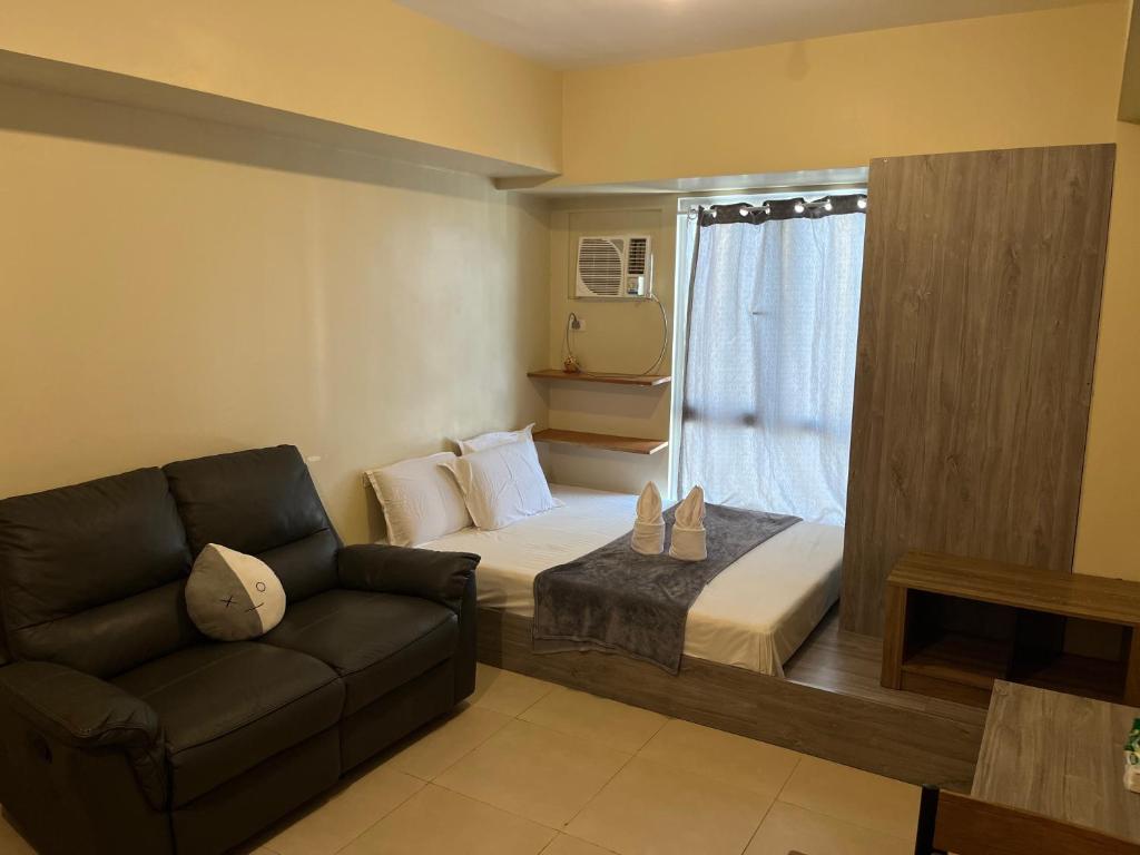 Avida Riala Tower 3 unit 2614 في مدينة سيبو: غرفة معيشة بها سرير وأريكة
