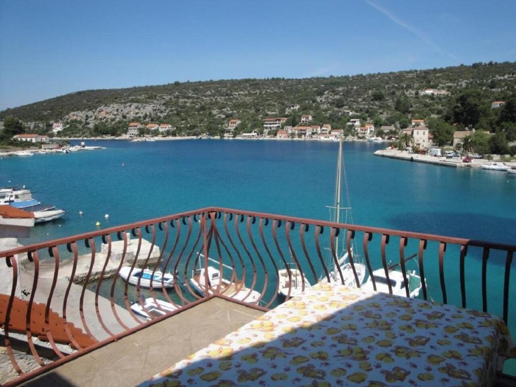 een balkon met uitzicht op een waterpartij bij Apartments Niki in Veliki Drvenik