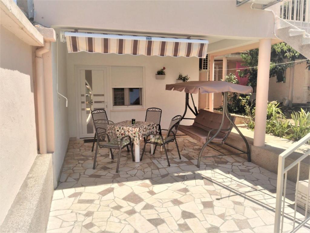 a patio with a table and chairs and an umbrella at House Boris in Slatine