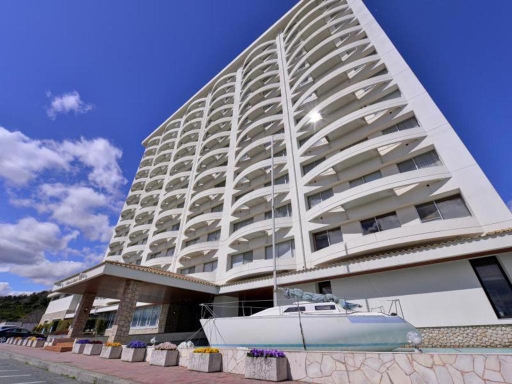 ein großes Gebäude mit einem Boot davor in der Unterkunft Hamanako Lake Side Plaza in Hamamatsu