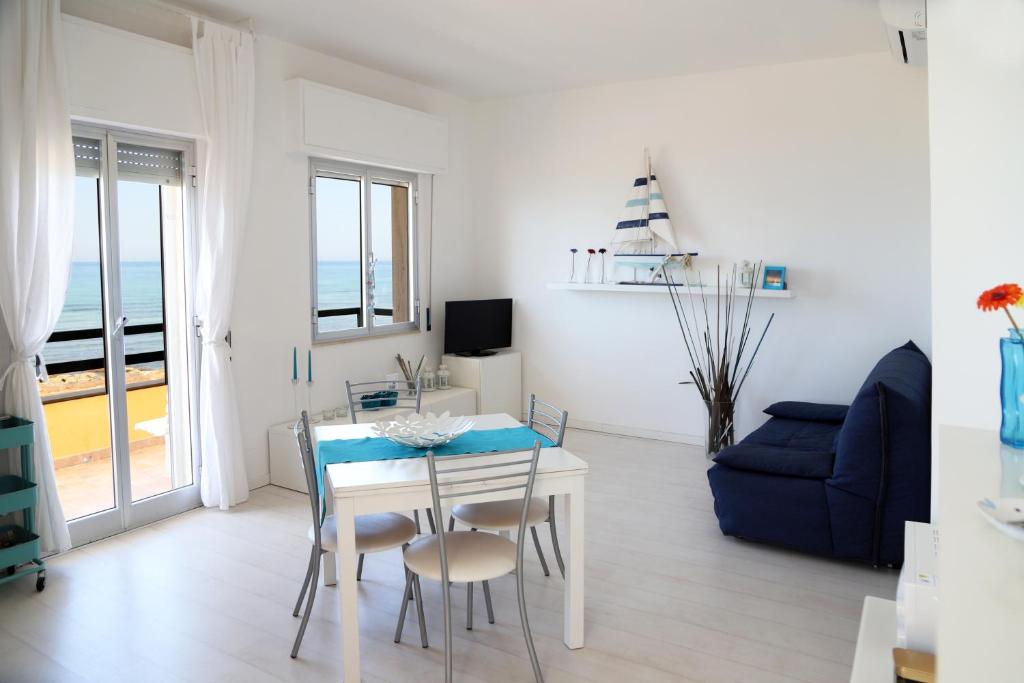 a living room with a table and a blue couch at Kaary Bella Vista in Marina di Ragusa