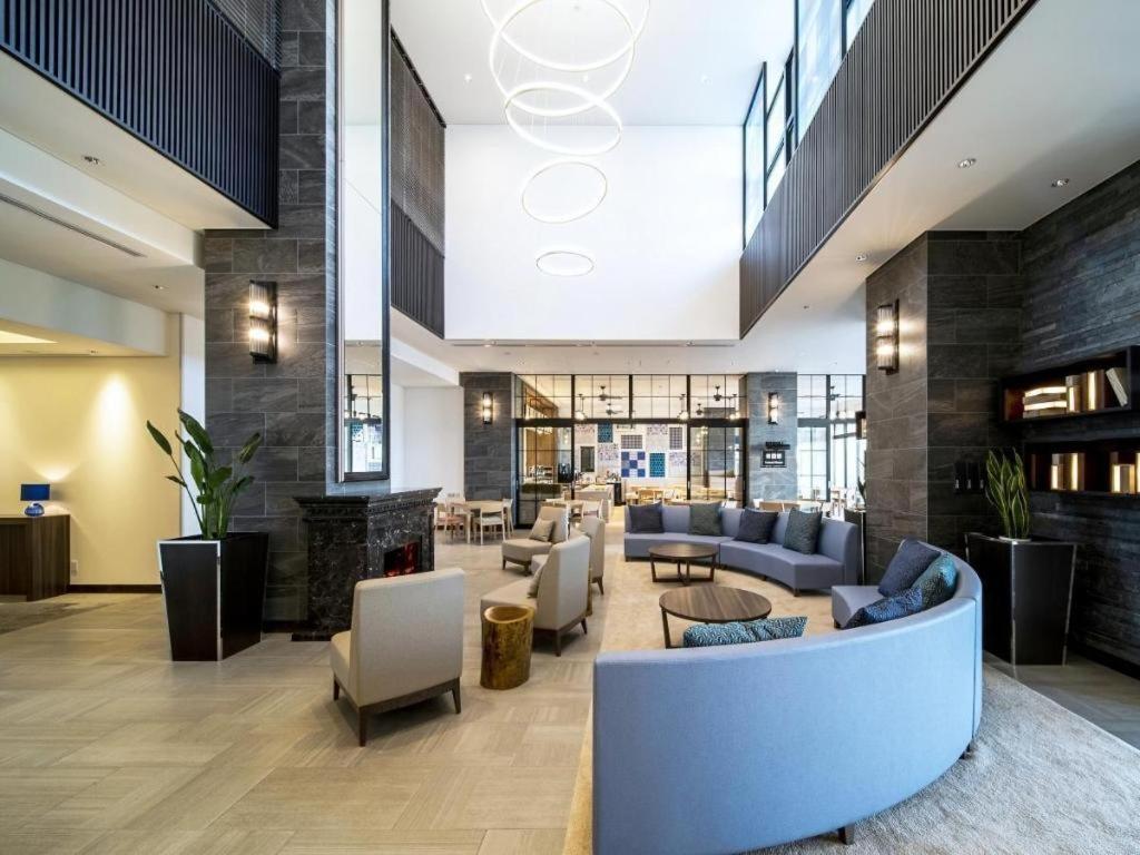 vestíbulo con sofás, sillas y chimenea en Goto Tsubaki Hotel, en Hukue