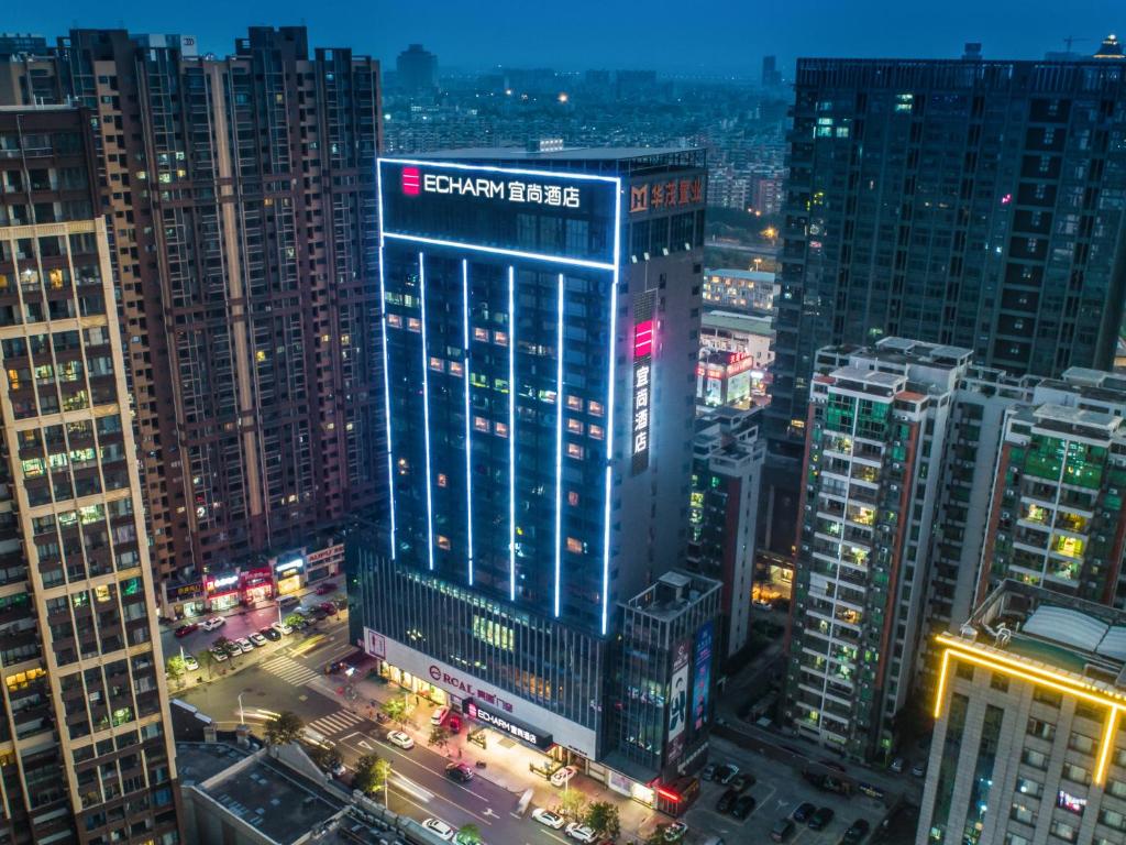 a lit up building in a city at night at Echarm Hotel - Foshan Sanshui Wanda Plaza in Sanshui