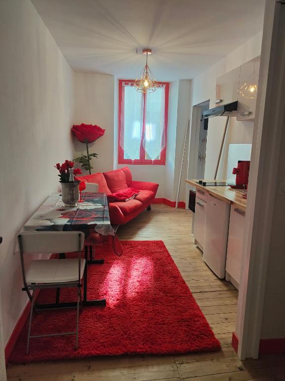 - un salon avec un canapé rouge et un tapis rouge dans l'établissement Le romantique, à Argelès-sur-Mer