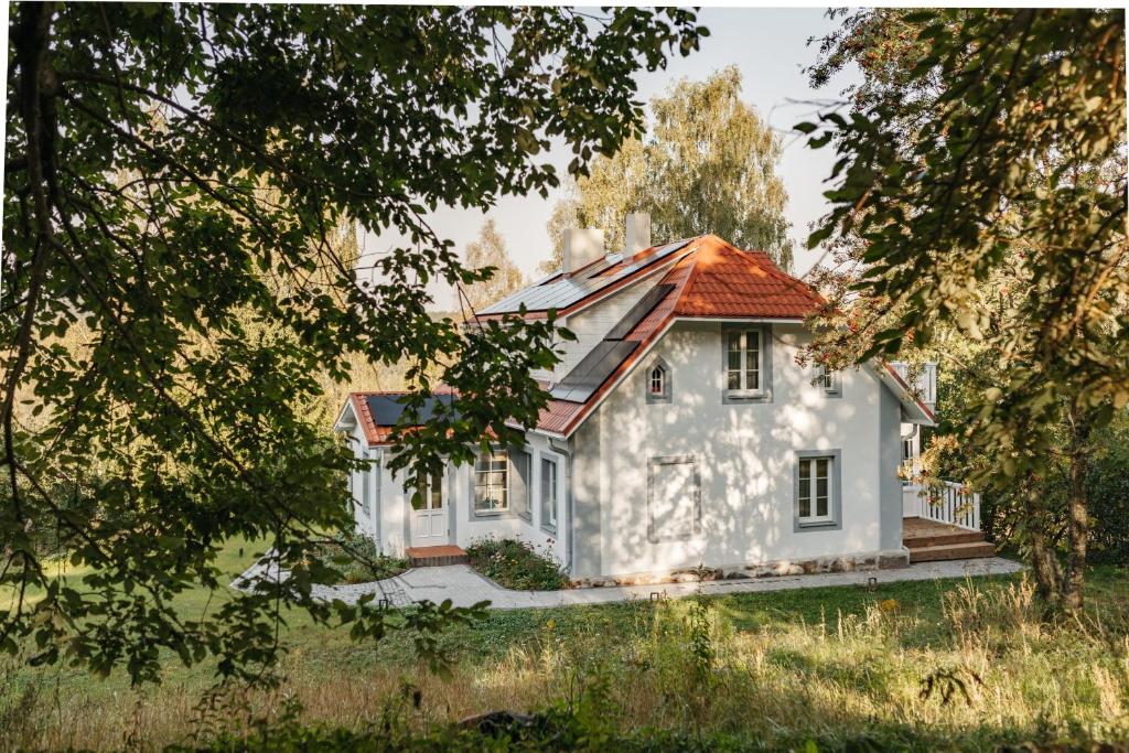 a small white house with an orange roof at Žagaru māja in Cēsis