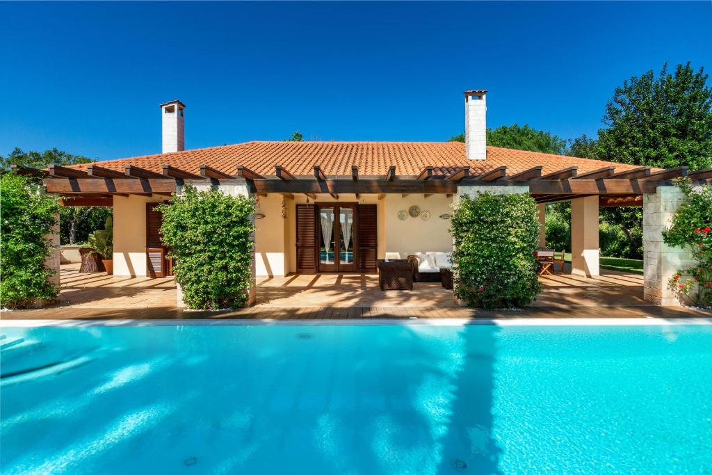 a villa with a swimming pool in front of a house at Villa Monica by BarbarHouse in Polignano a Mare